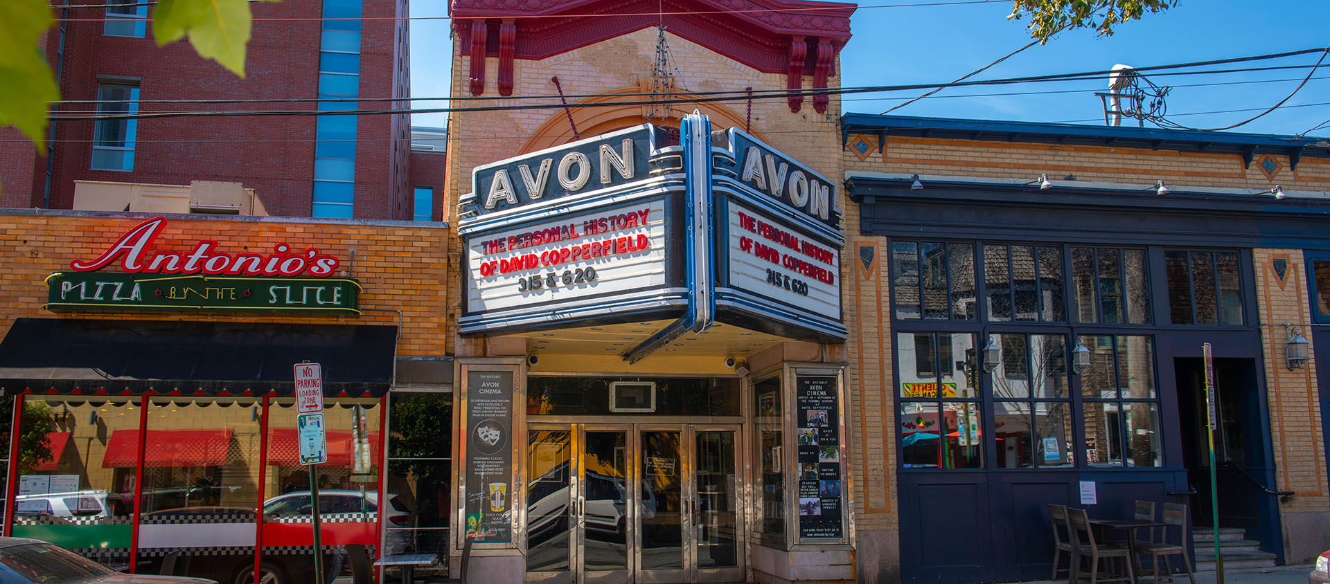 Providence streetscape showing Avon Theater and Antonio's Pizza by the Slice.